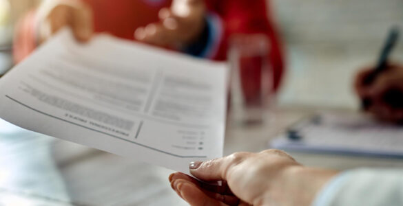 closeup job applicant giving his resume during job interview office