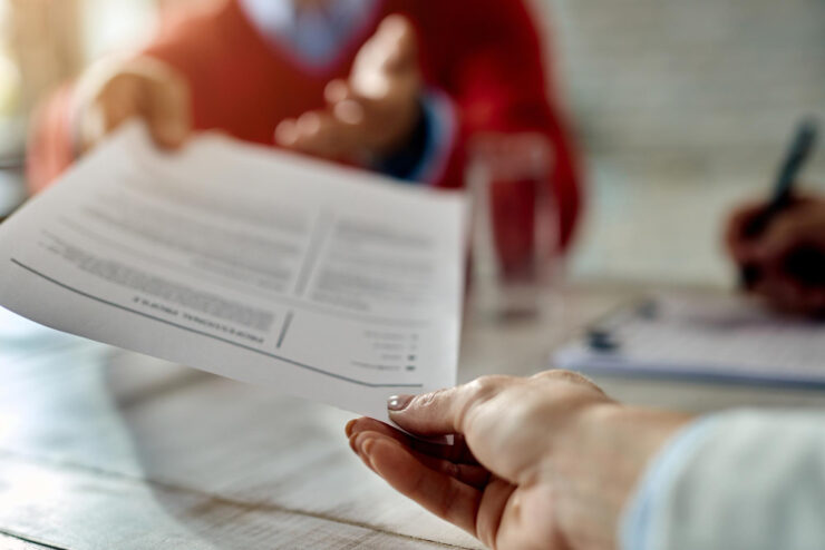 closeup job applicant giving his resume during job interview office