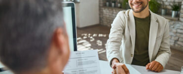 happy male candidate greeting member human resource team job interview office