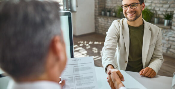 happy male candidate greeting member human resource team job interview office